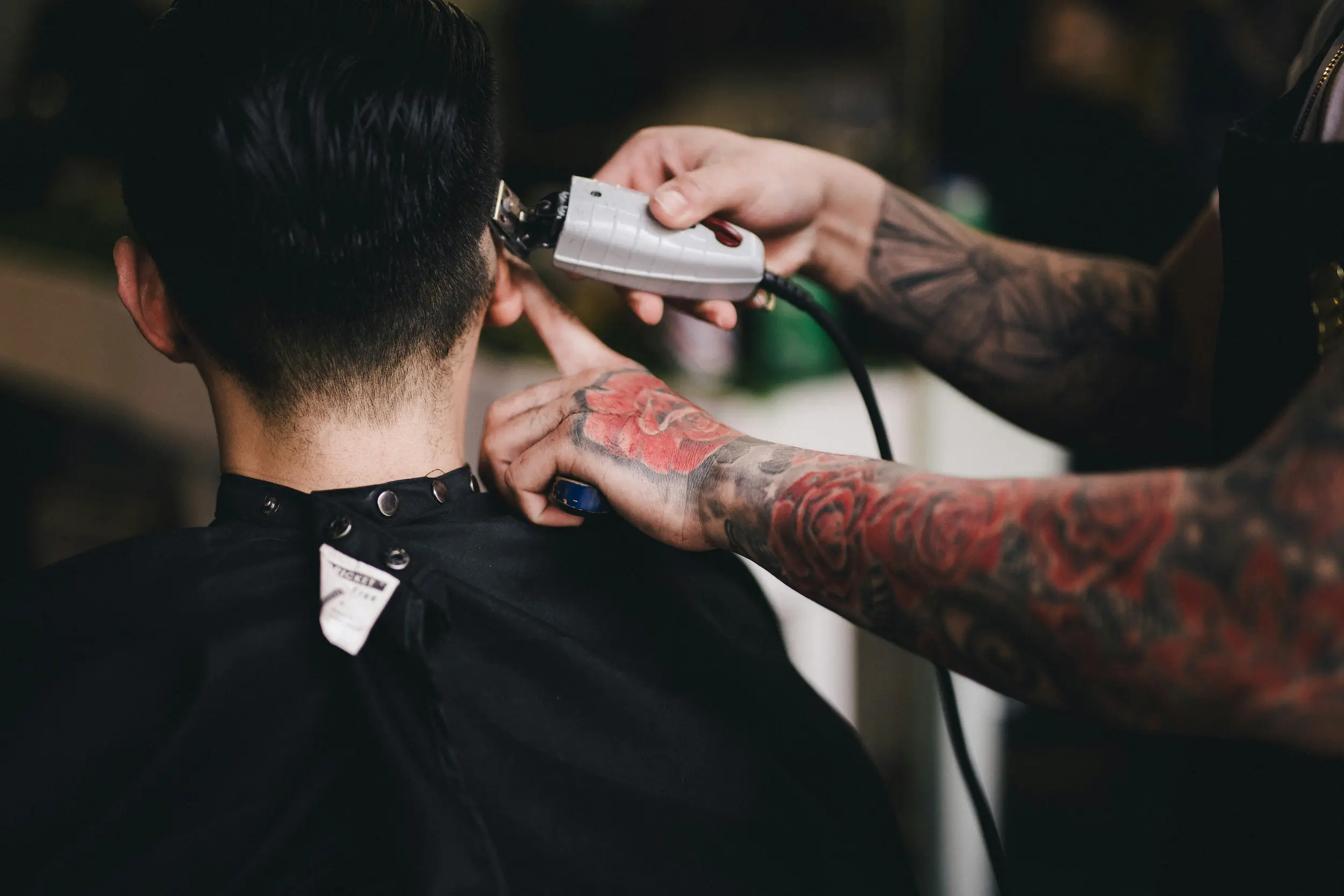 Barber giving a classic men's haircut at Clipper Craft Barbershop in Edmonton
